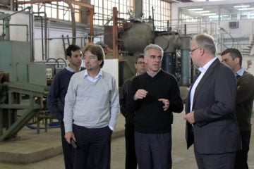 O pesquisador Mário Boccalini Junior (ao centro) apresenta aos executivos da Brasmetal as instalações do LMMC