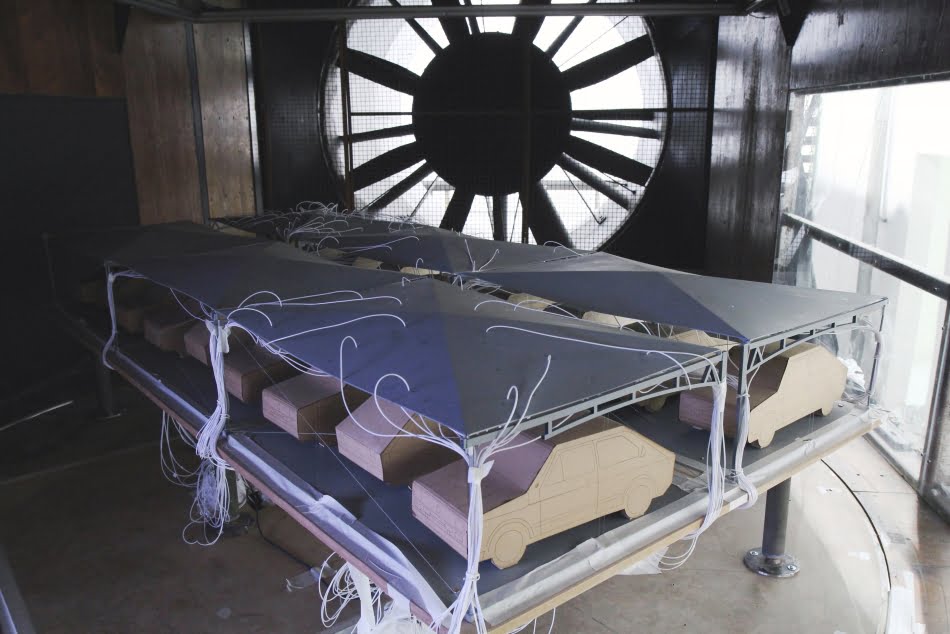 Ensaios foram feitos com e sem a inclusão de maquetes de automóveis para verificar a sua influência no carregamento do vento nos sombrites