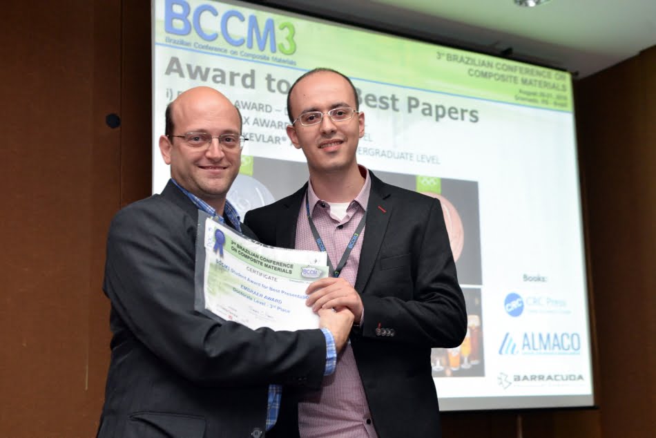 Researcher Vitor Luiz Reis (on the right) got the third place with the paper <em>Computational Study for Design of the Gas Gun Apparatus to Impact Tests on Composite Materials</em>. Photo: Fabiano Panizzi” class=”wp-image-41883″ width=”323″/><figcaption class=