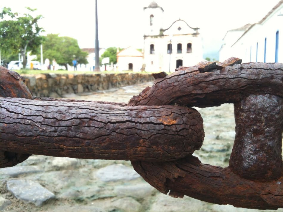 Foto da corrente corroída em frente à Igreja Nossa Senhora das Dores na cidade de Paraty (RJ) é obra da pesquisadora Anna Ramus Moreira